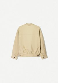 Beige leichte Jacke mit einem Stehkragen, elastischem Saum und Knopfdetails an den Manschetten. Glatte Textur und minimalistisches Design.