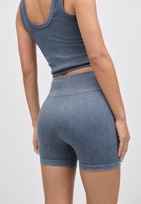 Ribbad mörkblå atletisk linne- och shortssel med figurnära passform, mjuk textur och resår i midjan för komfort.