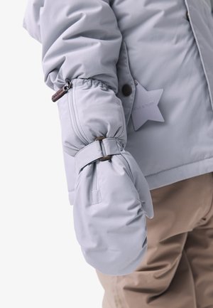 Des mittens gris clair attachés à une veste rembourrée. Le poignet est froncé avec une sangle ajustable, et une étiquette en forme d'étoile est visible.
