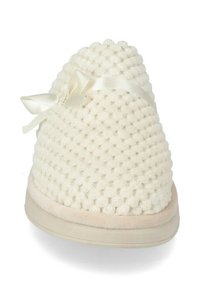 Pantofole bianche in maglia con una superficie testurizzata, dotate di un piccolo nastro decorativo e una suola liscia di colore chiaro.
