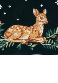 Broderad rådjur som ligger på gröna tallgrenar med röda bär, vita snöflingor på mörk tygbakgrund.