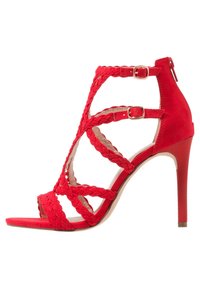 Červené semišové sandály na vysokém podpatku s tkanými pásky, otevřenou špičkou, uzavíráním na přezku kolem kotníku a elegantním stiletto podpatkem.