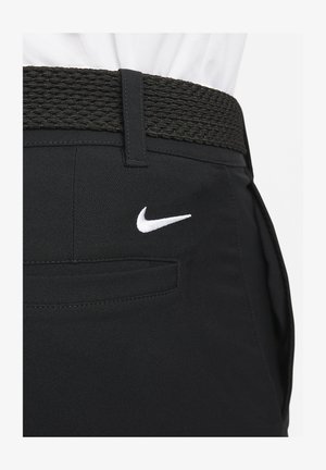 Mustat housut, jotka on valmistettu sileästä kankaasta, sisältävät kudotun mustan vyön ja pienen valkoisen Nike-logon takataskussa.