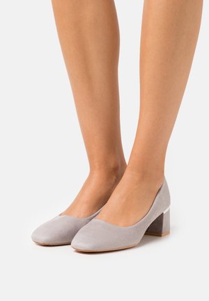 Chaussures à talon bloc en suède gris avec un bout arrondi et un design échancré, présentant un accent de talon contrastant.