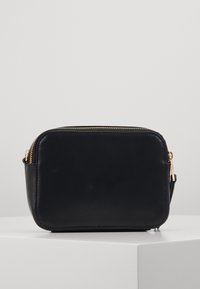 Sort læder crossbody taske med rektangulær form, guldlåsdetaljer og en glat overflade. Kompakt design velegnet til det nødvendige.