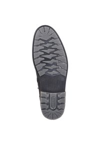 Suela de zapato negra con goma texturizada para un mejor agarre, presentando un patrón de zigzag y ranuras horizontales. Área del talón reforzada con detalle del logo.