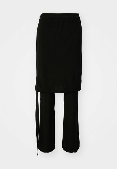 Conjunto preto de duas peças com uma saia longa com um laço lateral e calças largas. Feito de tecido suave com um design fluido.