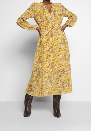 Gelbes, floral bedrucktes Maxikleid mit langen Ärmeln, V-Ausschnitt und gerüschter Taille. Es besteht aus einem leichten, durchsichtigen Stoff mit einem gestuften Rock.