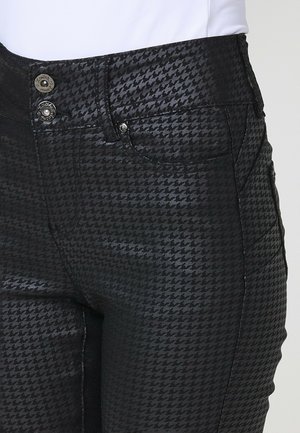 Schwarze Jeans mit einem Hahnentrittmuster, zwei Knopfverschlüssen an der Taille und seitlichen Taschen mit einer glatten Textur.