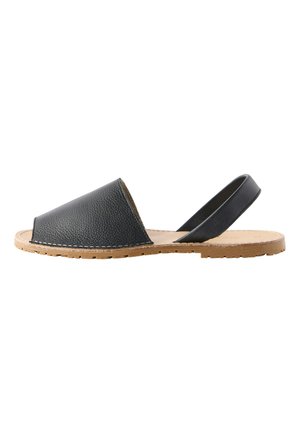 Schwarze Leder-Sandale mit offenem Zehenbereich, flacher Sohle in Hellbraun und elastischem Fersenriemen, Seitenansicht auf weißem Hintergrund.