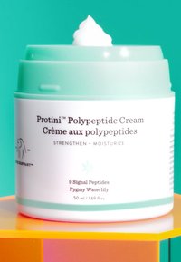 Light green jar with a white lid, featuring a swirl of cream on top. Text includes "Proteini Polypeptide Cream," 50 ml/1.69 fl oz, with ingredient details.