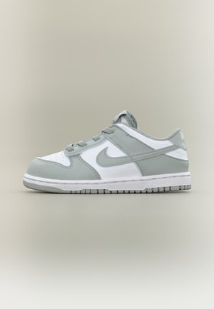 Niski szary i biały sneaker Nike ze sznurowadłami, perforowaną przednią częścią i gumową podeszwą, pokazany z zewnętrznej strony na jednolitym tle.