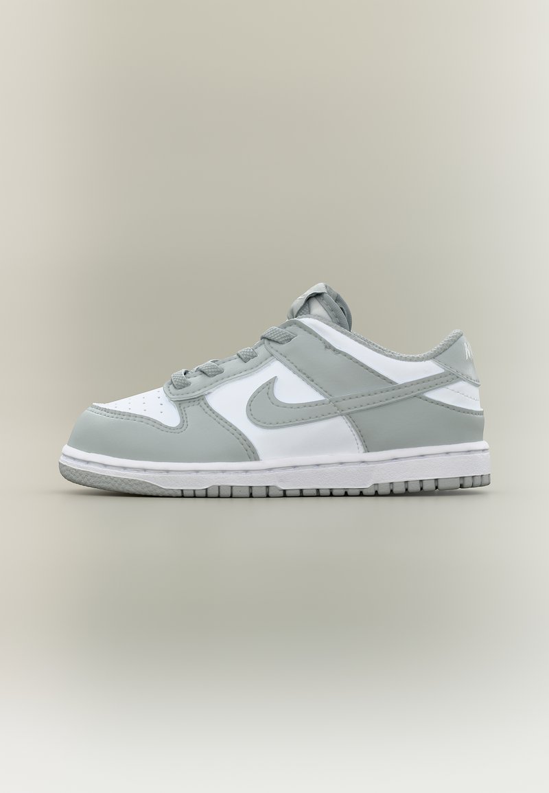 Χαμηλό γκρι και λευκό αθλητικό παπούτσι Nike με κορδόνια, διάτρητο μπροστινό μέρος και λαστιχένια σόλα, εμφανισμένο από την εξωτερική πλευρά σε απλό φόντο.