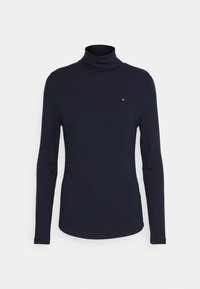 Mörkblå ribbad polotröja med långa ärmar. Har en liten logotyp på bröstet. Tillverkad av mjukt, stretchigt material.