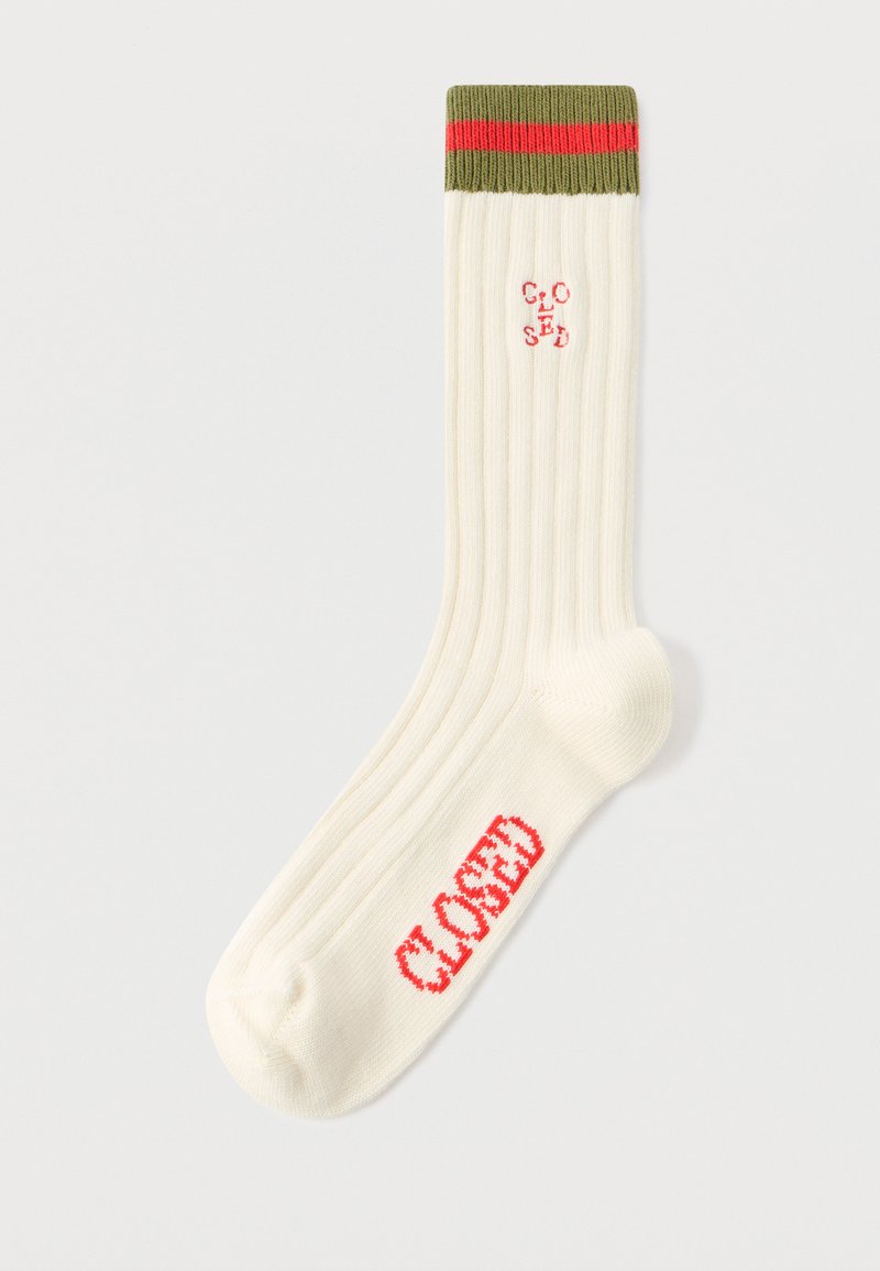 Chaussettes côtelées couleur crème avec un revers rayé vert et rouge. Le nom de la marque "CLOSED" est brodé en rouge sur le côté.
