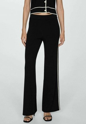 Schwarze Schlaghosen mit weitem Bein, ausgestattet mit einem kontrastierenden weißen Seitenstreifen. Hergestellt aus weichem Stoff mit glatter Textur und einem taillierten Bund.