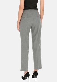 Szare spodnie o dopasowanym kroju z gładką fakturą, dwoma tylnymi kieszeniami, prostymi nogawkami i dopasowanym pasem, zestawione z czarnymi szpilkami.