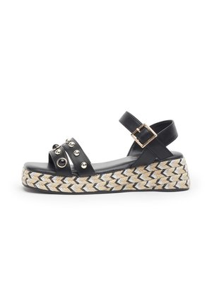 Sandalo con zeppa nero con cinturino alla caviglia, fibbia dorata, cinturini anteriori borchiati e suola platform intrecciata beige e bianca.
