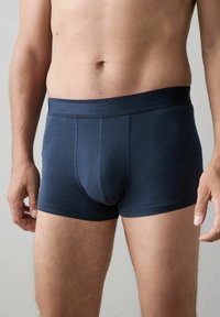 Mörkblå boxerkalsonger i stretchigt tyg. Har ett elastiskt midjeband med varumärkestryck och en figurnära design med synliga sömtdetaljer.