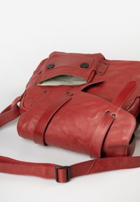 Borsa in pelle rossa con chiusura a patta, due bottoni neri e superficie texturizzata. Presenta una tracolla regolabile e un interno con rivestimento a righe.