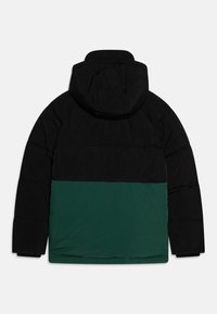 Puffer jacket with a black upper section and green lower section. Features a hood, quilted texture, and elastic cuffs.