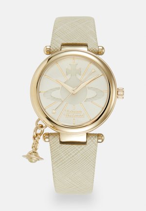 Goldfarbene Uhr mit einem strukturierten beigen Armband, rundem Ziffernblatt und einem filigranen hellcremefarbenen Ziffernblatt mit Sonnenstrahlenmuster und Vivienne Westwood-Logo.