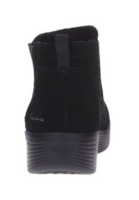 Stivaletti in suede neri con suola imbottita, dotati di un pratico manicotto sul retro e sottili dettagli di cucitura lungo i lati.