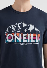 Camiseta de algodón azul marino con un estampado gráfico de montañas y el nombre de la marca "O'NEILL" en letras de bloque coloridas.