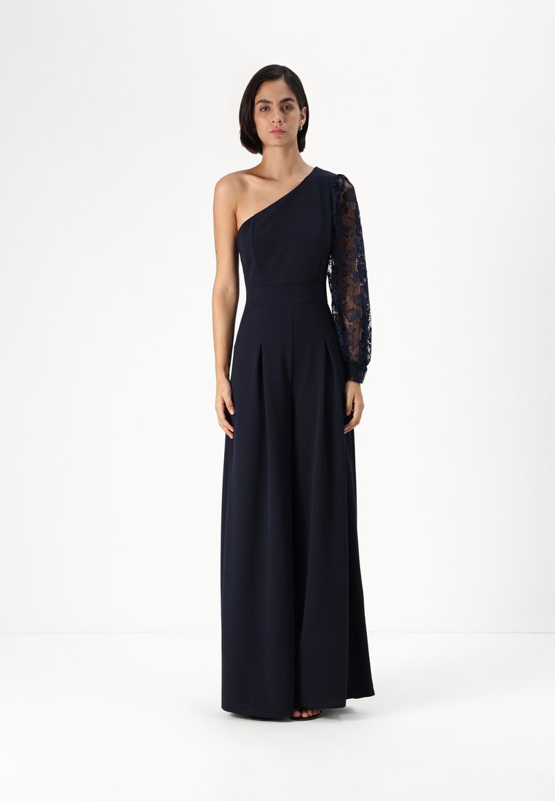 Navy blue dress with one shoulder design; the other sleeve features lace detailing. Fabric is smooth with a wide-leg cut and pleats.