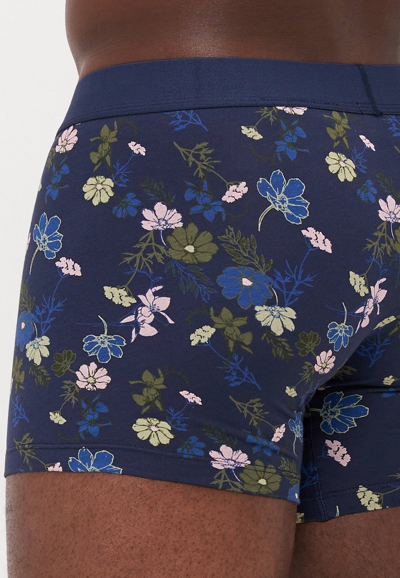 Bañador estampado en azul marino con flores que presentan una mezcla de flores en rosa, verde y azul, confeccionado con una tela suave y elástica y una cinturilla sólida.