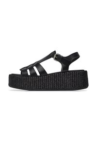 Sandali platform neri con texture intrecciata, dotati di cinturini incrociati, una cinghia regolabile alla caviglia e una base spessa e intrecciata.