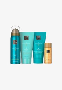 Set di quattro prodotti per la cura della pelle in confezioni turchesi e dorate: gel doccia schiumogeno, pasta scrub, lozione idratante e olio per il corpo scintillante.