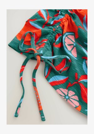 Bunt gemustertes Stoffmaterial mit leuchtend orangen und blauen Blumen auf grünem Hintergrund, mit einem Kordelzug für eine verstellbare Passform.