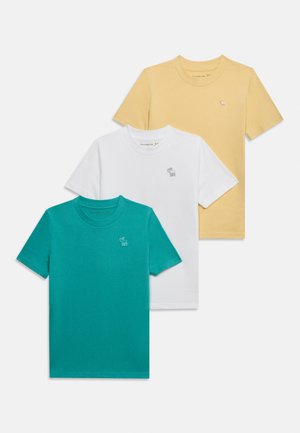 Tre magliette a maniche corte con scollo rotondo, nei colori teal, bianco e giallo, ciascuna con un piccolo logo ricamato di un alce sul petto.