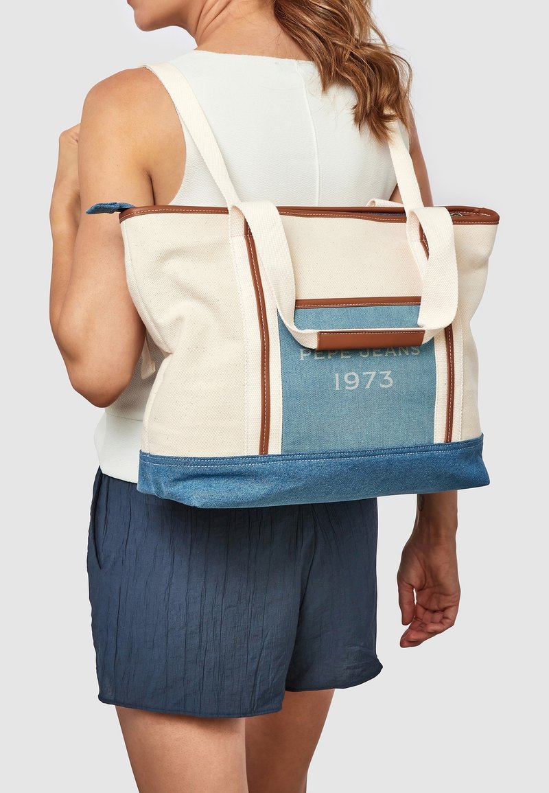 Plátěná taška s akcenty z hnědé kůže, s modrými a krémovými panely. Na akvamarínové části je vytištěno "PEPE JEANS 1973". Robustní design.