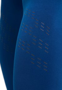 Leggings atletici blu con una finitura testurizzata; presentano un motivo sottile di linee scure intrecciate nel tessuto per un'aderenza e uno stile superiori.