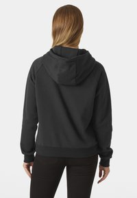 Černá mikina s kapucí vyrobená z měkké látky, s nastavitelnou kapucí, volným střihem a ribovanými manžetami a lemem. Hladká textura, minimalistický design.