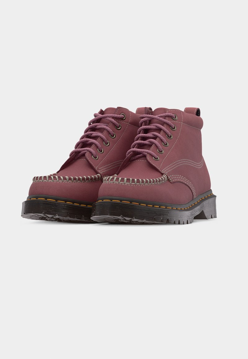 Pair of mauve leather ankle boots with thick black soles, pink laces, stitching details, and metal eyelets on a white background.