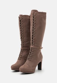 Hnědé semišové půlčástečné boty až ke kolenům s jemně špičatou špičkou, šněrováním v přední části, akcentem v podobě přezky a širokým podpatkem. Hladký povrch s jemným zakončením.