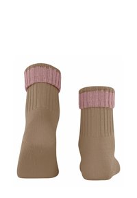 Chaussettes marron avec un design côtelé et un poignet rose. Le tissu semble doux et extensible, mettant en valeur des accents de couleur contrastés.