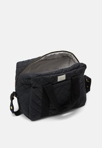 Borsa in tessuto nero trapuntato con zip dorata, interno grigio, doppi manici e tasca laterale. La struttura è rettangolare con una texture morbida.