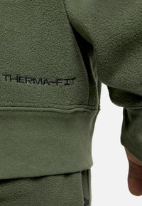 Grüner Fleece-Pullover mit gesticktem "THERMA-FIT" in Schwarz. Das Design umfasst eine weiche Textur sowie gerippte Bündchen und Saum.