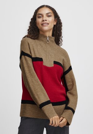 Strickpullover mit Reißverschlusskragen, in Khaki mit roten und schwarzen geometrischen Mustern. Der Stoff hat eine weiche Textur und gerippte Bündchen.
