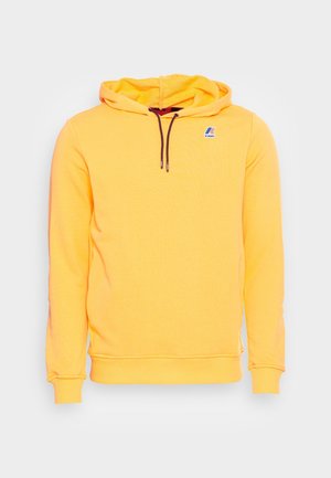 Yellow hooded sweatshirt with a textured finish, featuring brown drawstrings and a small blue logo on the left chest. Long sleeves with ribbed cuffs.