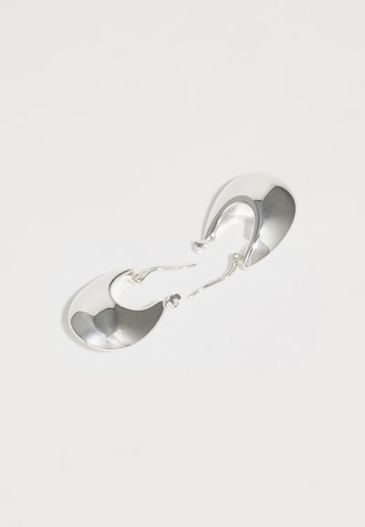 Boucles d'oreilles en argent en forme de créoles avec une finition polie, présentant une forme en goutte d'eau et une surface lisse et réfléchissante. Fermoir simple en crochet.