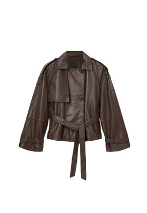 Brązowa skórzana kurtka o kroju cropped, z szerokimi rękawami, paskiem i zapięciem na guziki z przodu. Posiada kieszonkę na piersi i gładką fakturę.