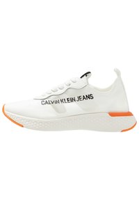 White low-top sneaker with hexagonal patterned sole, orange accents, and "Calvin Klein Jeans" logo on the side and heel tab.