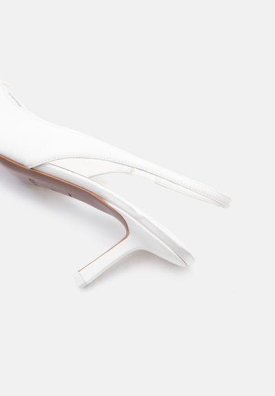 Chaussure à talon haut en cuir blanc avec brides arrière, bout pointu et talon stiletto fin sur un fond uni clair.