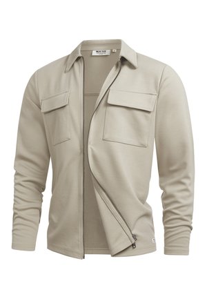 Giacca beige chiaro con zip, due tasche con patta sul petto e colletto classico, mostrata parzialmente aperta su sfondo bianco.