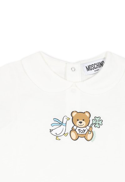 Wit katoenen babyspeelpakje met een kraag; heeft een cartoonbeer en eend grafiek met de tekst "TOY". Etiket leest "Moschino Baby."